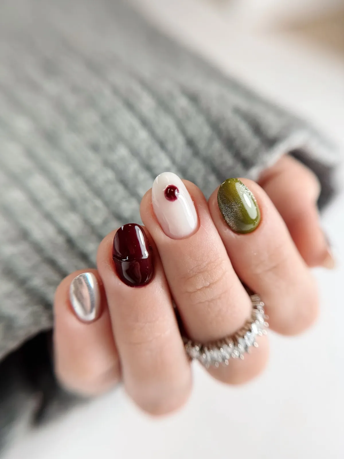 Nail art de saison : bordeaux profond, blanc lacté, vert olive et chrome argenté